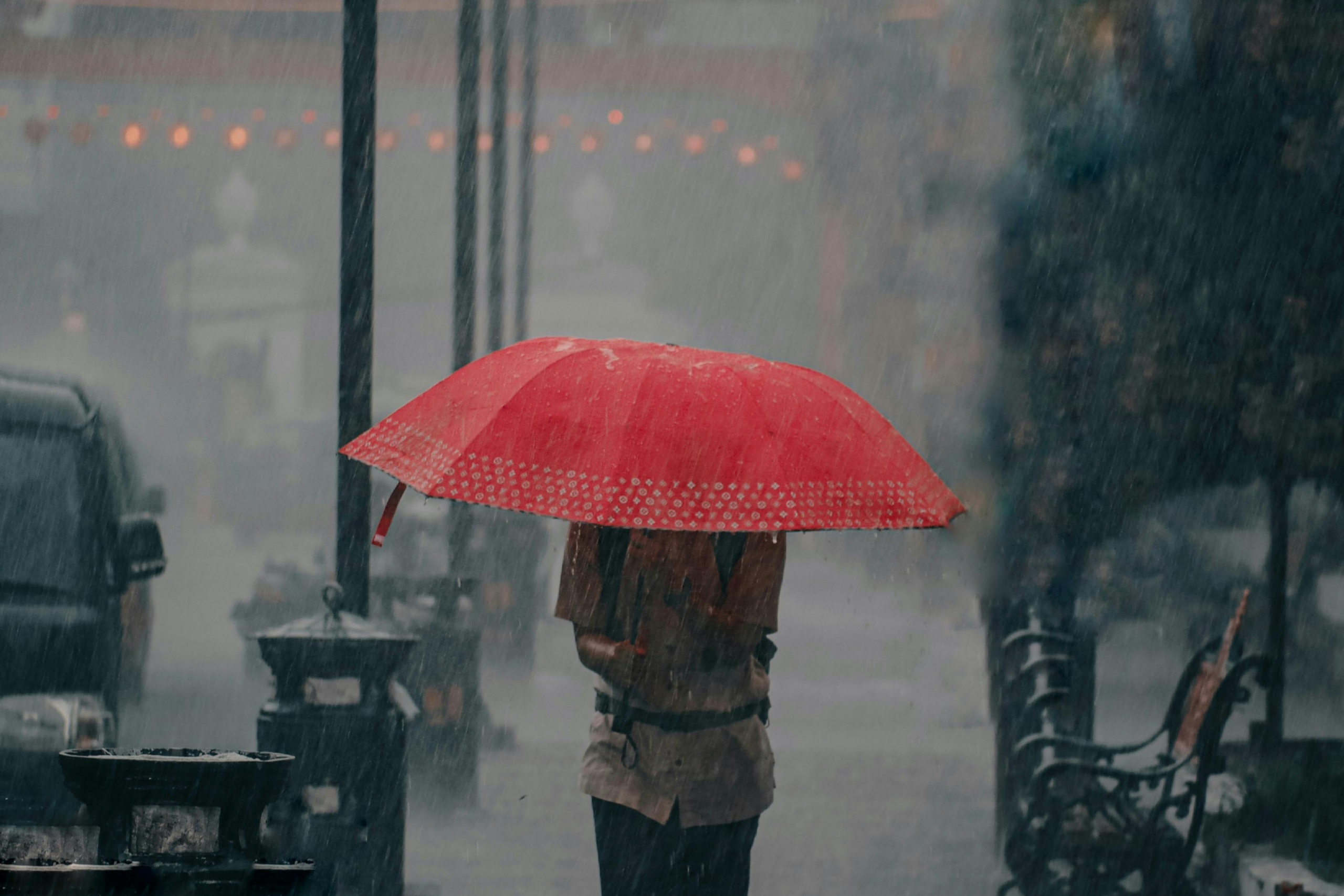 men with red umbrella in a rainstorm